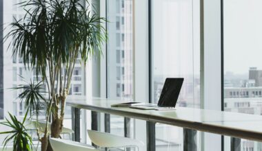 Hyggelig arbejdsplads med bærbar computer nær et stort vindue